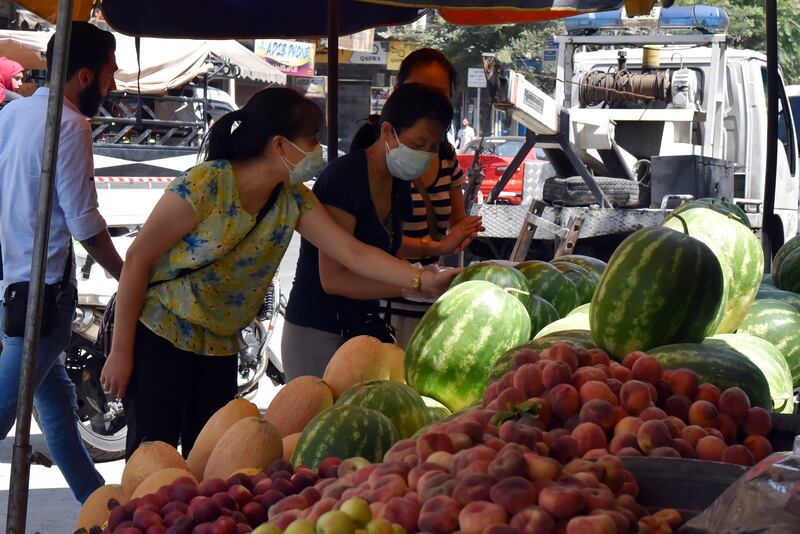 Syrians shop for vegetables at a market in Damascus on Sunday July 11, hours after Syrian President Bashar Al Assad issued a legislative decree granting civil servants and military members a 50 per cent pay rise. The decision comes a day after the government raised the price of fuel by more than 50 per cent for the third time this year. EPA