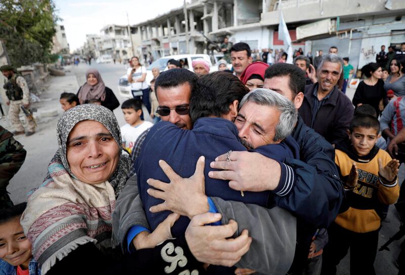 Relatives hug one of the hostages held by Islamic State militants who escaped from his captors in Qaryatayn town in Homs province, Syria. Omar Sanadiki / Reuters
