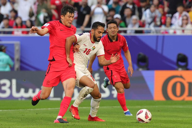 South Korea's Lee Ki-je vies for the ball with Jordan's Musa Al Tamari in Doha on Saturday. AFP