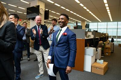 Wesley Morris, right, critic-at-large, is congratulated by colleagues after being awarded the Pulitzer Prize for criticism, in the newsroom at The New York Times headquarters in New York, on Friday, June 11, 2021. (Damon Winter/The New York Times via AP)