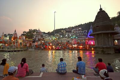 In this picture taken on June 11, 2020, Hindu devotees attend evening prayers at Har Ki Pauri ghat on the banks of the river Ganges, after the government eased a nationwide lockdown imposed as a preventive measure against the COVID-19 coronavirus at Haridwar in Uttarakhand state. Life is slowly returning to normal among the hallowed temples of Haridwar, one of Hinduism's holiest places, but the Indian pilgrimage town still has a forlorn air as the country emerges from its coronavirus lockdown. - TO GO WITH Virus-health-India-religion-tradition-tourism,SCENE by Bhuvan BAGGA
 / AFP / Money SHARMA / TO GO WITH Virus-health-India-religion-tradition-tourism,SCENE by Bhuvan BAGGA
