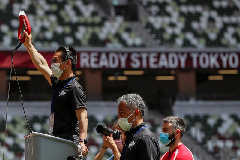 Officials are seen wearing masks during the morning session of the athletics test event. Reuters