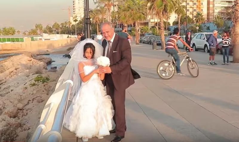A frame from the Kafa video showing an older groom and child bride. (Kafa/ YouTube)