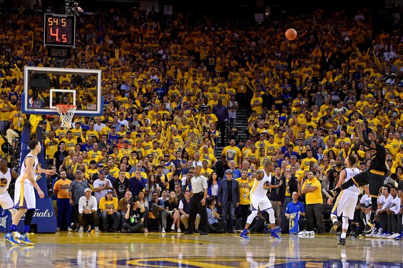 Cleveland Cavaliers guard Kyrie Irving, right, shoots a 3-point basket against the Golden State Warriors during the second half of Game 7 of basketball's NBA Finals in Oakland, Calif., Sunday, June 19, 2016. The Cavaliers won 93-89. (Jose Carlos Fajardo/Bay Area News Group via AP) MAGS OUT NO SALES MANDATORY CREDIT