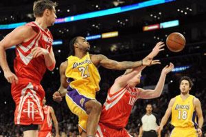 Josh Powell, 21, of the Lakers tries to grab a rebound from Chase Budinger, 10, of the Rockets.