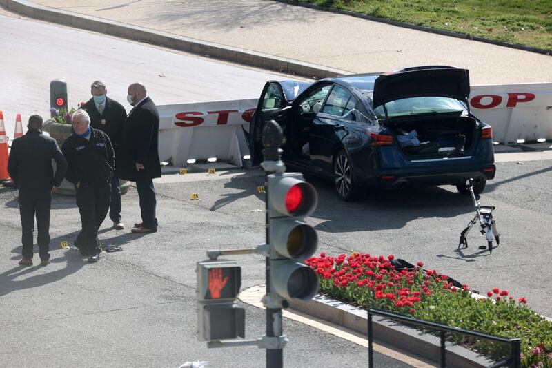 Law enforcement officers investigate the scene. The driver of the vehicle, named as Noah Green, was shot dead by police. AFP