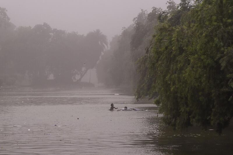 Indian children swim in a pond during a dust storm in New Delhi on May 2. Chandan Khanna / AFP Photo