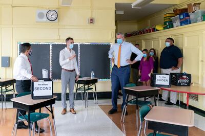 Kevyn Bowles, principal of New Bridges Elementary, speaks while Bill de Blasio, mayor of New York, listens during a news conference at New Bridges Elementary School, ahead of schools reopening, in the Brooklyn borough of New York City, amid the coronavirus disease (COVID-19) outbreak in New York, U.S., August. 19, 2020.  Jeenah Moon/Pool via REUTERS