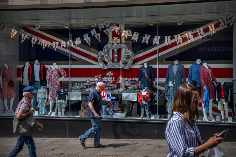 People pass a shop window display commemorating the platinum jubilee in Windsor. Getty Images