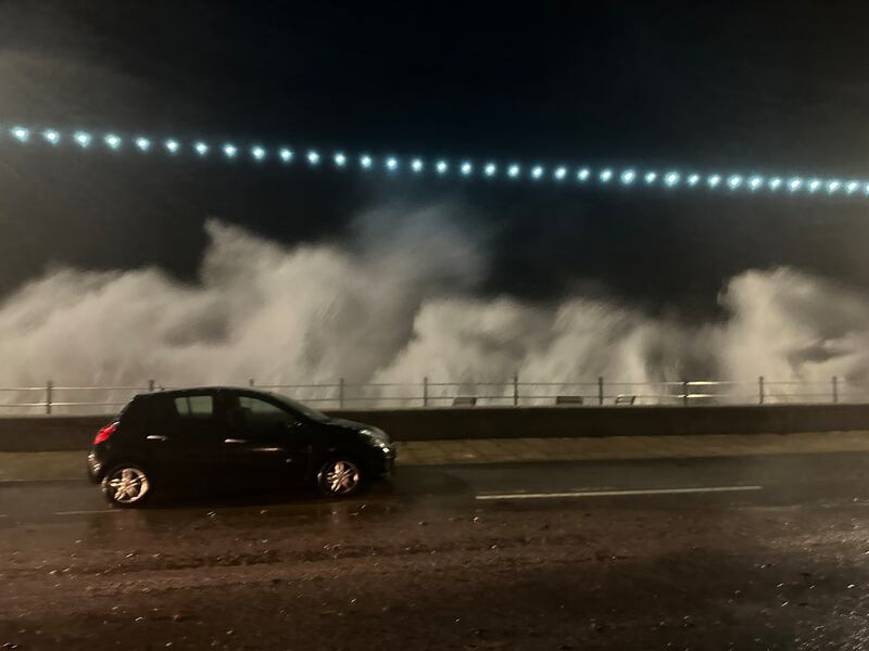 Waves crash over the sea wall in Penzance, Cornwall. PA