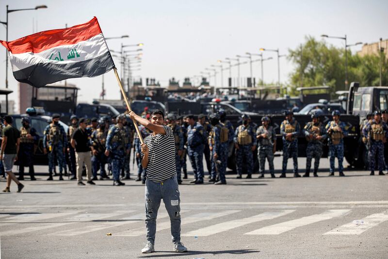 A supporter of Shiite Muslim cleric Moqtada Sadr waves an Iraqi national flag. AFP