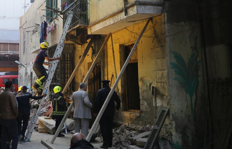 epa09013600 Egyptian rescue workers inspect the site where a three-storey building collapsed in Rawd Al-Farag, Cairo, Egypt, 15 February 2021. According to authorities, at least three people died after the building collapsed in the early hours.  EPA/KHALED ELFIQI