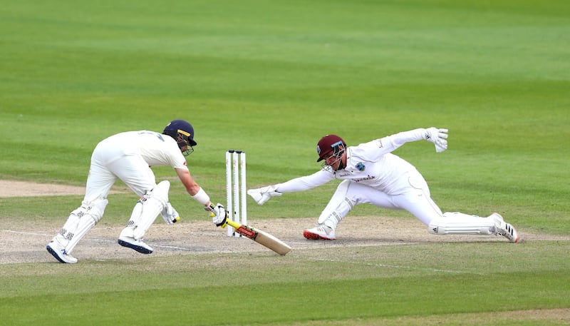 West Indies wicketkeeper Joshua Da Silva slips as he misses a chance to run out England's Rory Burns. PA