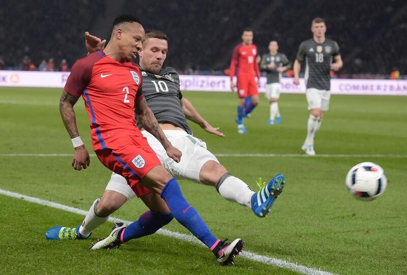 England’s defender Nathaniel Clyne (L) and Germany’s midfielder Lukas Podolski vie for the ball during the friendly football match Germany vs England at the Olympic Stadium in Berlin on March 26, 2016. / AFP / TOBIAS SCHWARZ