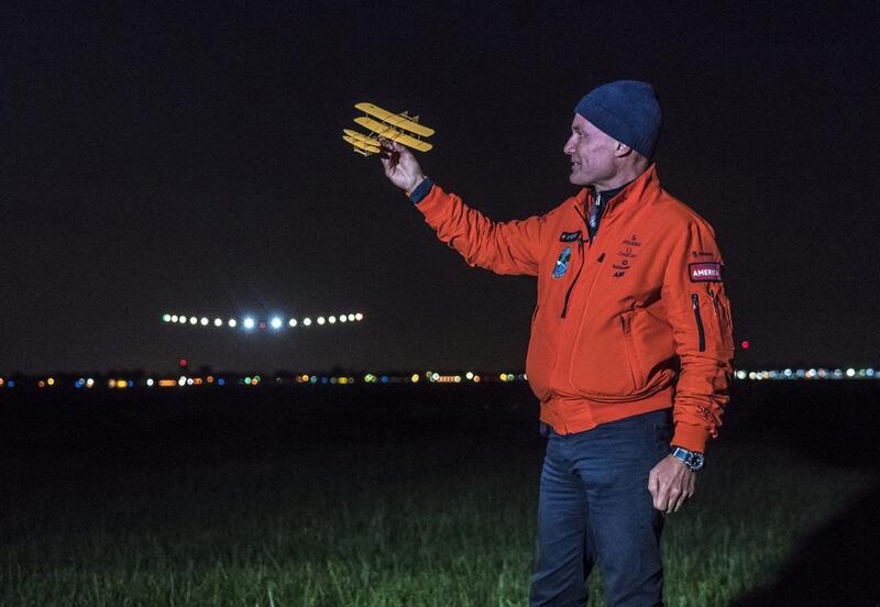 Swiss adventurer Bertrand Piccard holds a model of a plane designed by the Wright brothers as he welcomes the Solar Impulse 2, piloted by Andre Borschberg, to Dayton International Airport in Ohio on Saturday. Reuters