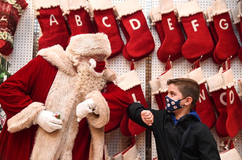 Santa Claus greets Jaythan Corbacho with an elbow bump during the Selfridges 2020 Christmas Shop 'once upon a Christmas' event at Selfridges, Oxford Street. Getty Images