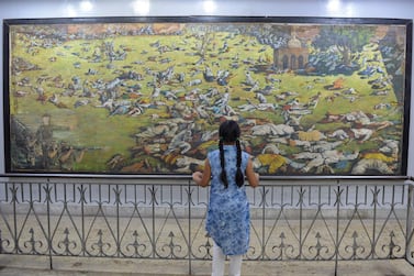An Indian girl looks at a painting commemorating the Jallianwala Bagh massacre in Amritsar on April 13, 1919, when British Indian Army soldiers opened fire on an unarmed gathering killing at least 379 people. Narinder Nanu / AFP