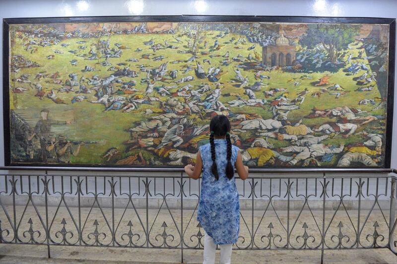 An Indian girl looks at a painting of the martyrs ahead of the 100th anniversary of the Jallianwala Bagh massacre in Amritsar on April 7, 2019. The Amritsar massacre, also known as the Jallianwala Bagh Massacre, took place on April 13, 1919, when British Indian Army soldiers on the direct orders of their British officers opened fire on an unarmed gathering killing at least 379 men, women and children, according to official records.  / AFP / NARINDER NANU
