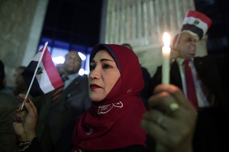 epa06354387 Egyptian Jornalists hold candles and the Egyptian national flag during candlelight vigil for victims of al-Rawda mosque attack, in front of the Journalists Syndicate, in Cairo, Egypt, 27 November 2017. 305 people were killed and 128 injured after a bomb was detonated at a mosque and fire opened on worshippers during Friday prayers in the Sinai town of Bir al-Abd, near Arish (400km northeast of Cairo) on 24 November.  EPA/KHALED ELFIQI