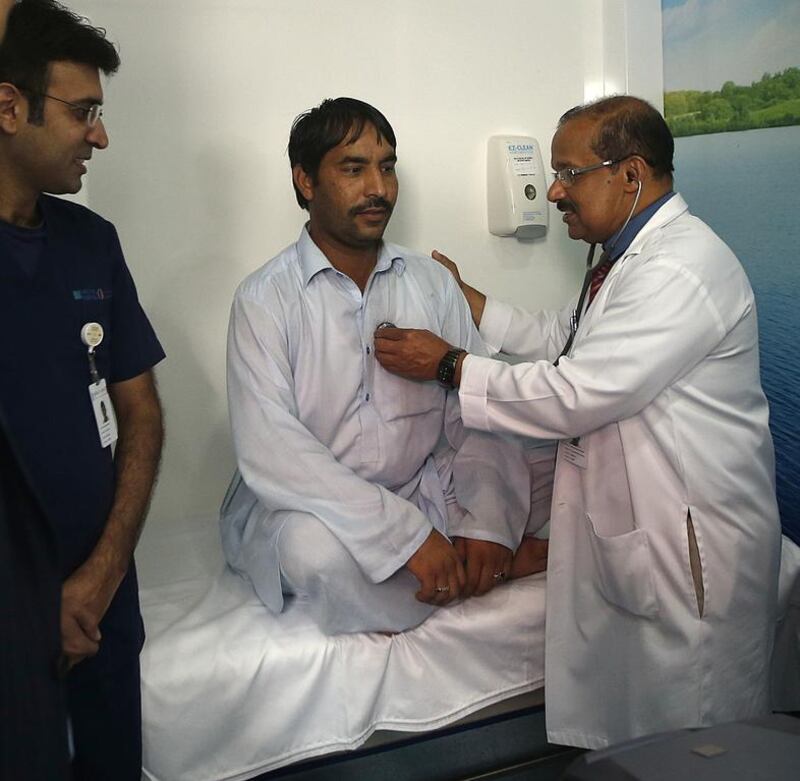 A doctor from Lifecare Hospital checks the health of a worker in Mussaffah after inaugurating the mobile clinics initiative. Ravindranath K / The National