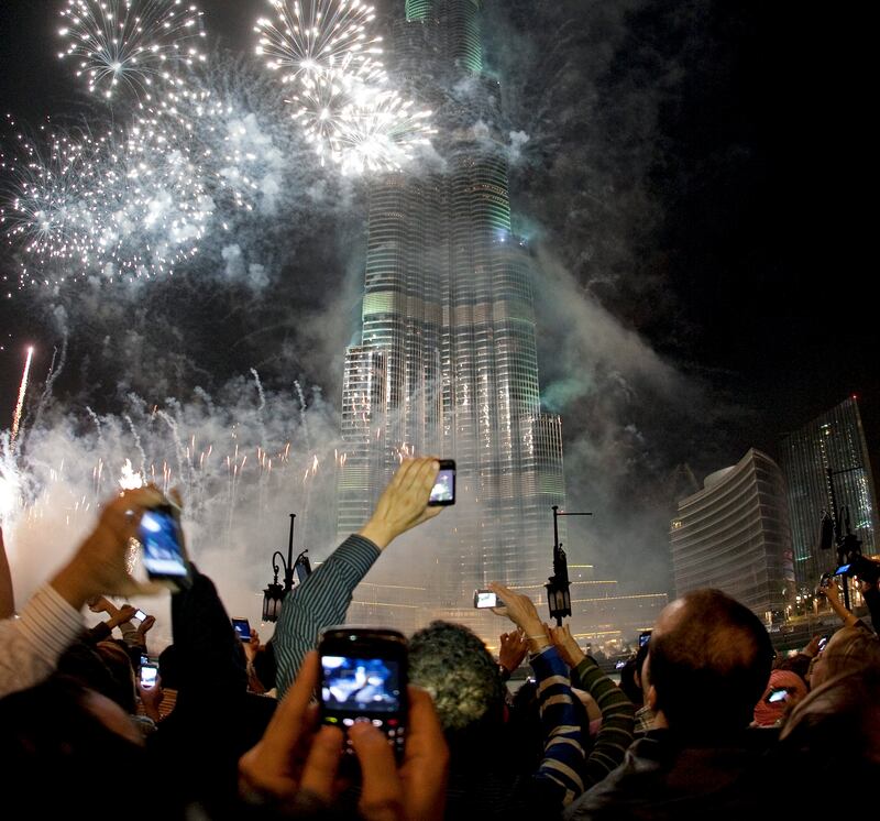 Dubai, December 31, 2010 - Spectators photograph the fireworks at the Burj Khalifa on New Year's Eve in Dubai, December 31, 2010. (Jeff Topping/The National) 