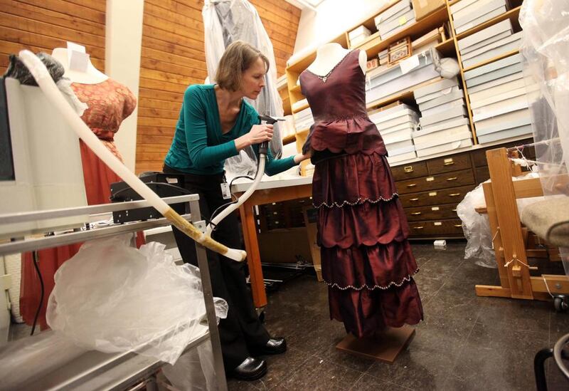 Kate Sahmel, a textile conservator, steams the engagement dress of character Mary. AP