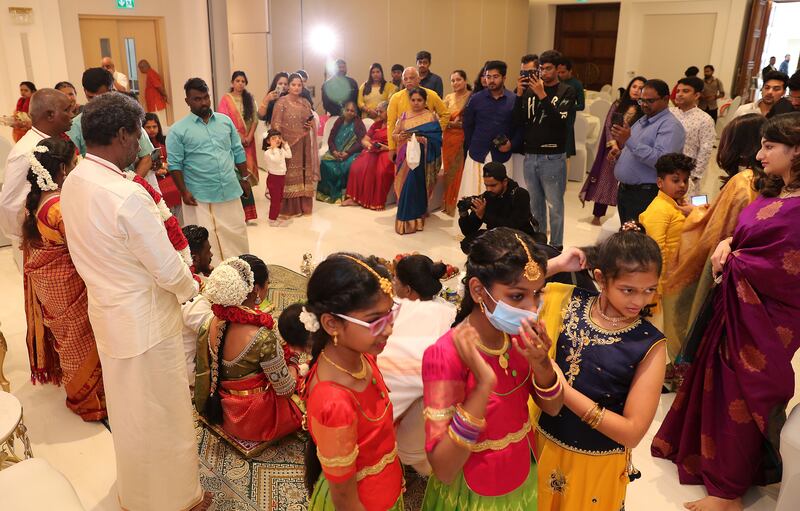 Well-wishers gather around the bridal couple in the community hall on the first floor of the temple