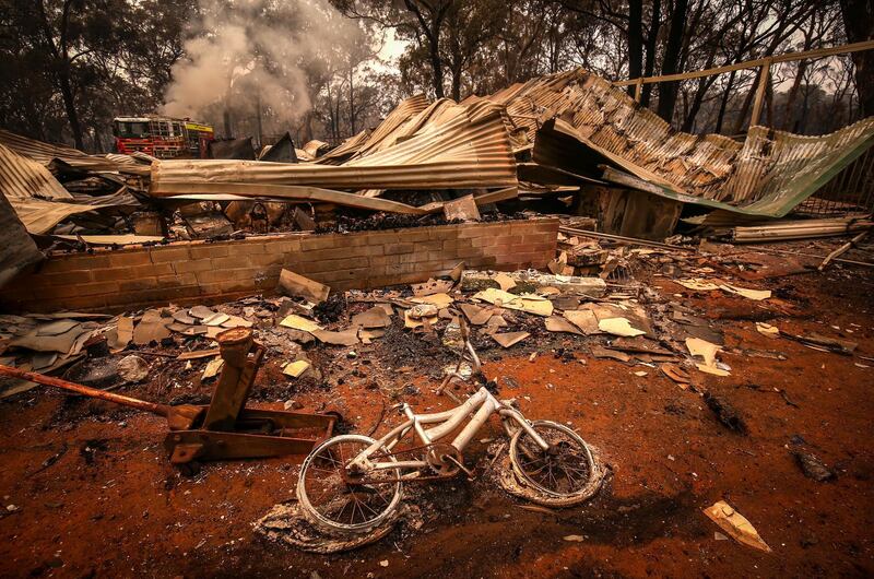 A burnt bicycle lies on the ground in front of a house recently destroyed by bushfires on the outskirts of the town of Bargo. Getty Images