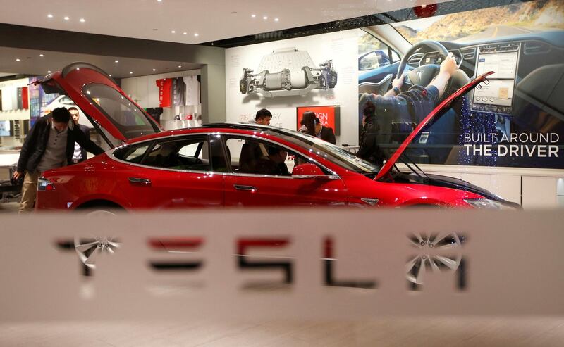 FILE PHOTO: A man looks at a Tesla Model S car at its showroom in Beijing, China January 29, 2014. REUTERS/Kim Kyung-Hoon/File Photo