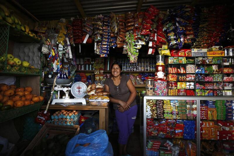 Irma Huaman poses for a photo in her grocery store in Gosen City. Huaman arrived in Gosen City 12 years ago when it was just a settlement. She initially worked as a street vendor, until she acquired a loan to build her own store. Mariana Bazo / Reuters