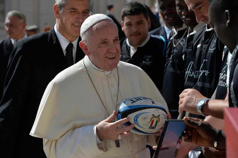 epa07014882 A handout picture provided by the Vatican Media shows Pope Francis (C) receiving a rugby ball signed by the members of a rugby team formed by refugees at the end of his general audience in St. Peter's Square at the Vatican, 12 September 2018. Others are not identified.  EPA/VATICAN MEDIA/HANDOUT  HANDOUT EDITORIAL USE ONLY/NO SALES