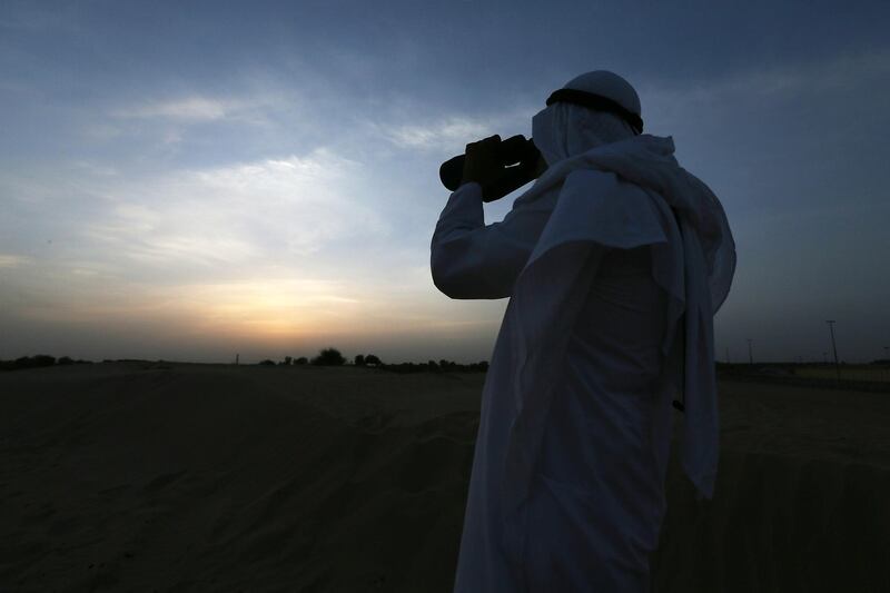 DUBAI , UNITED ARAB EMIRATES – July 9 : Hasan Al Hariri , an astronomer watching the Ramadan moon from his binocular near Mushrif park in Dubai. ( Pawan Singh / The National ) For News.  Story by Nadeem Hanif