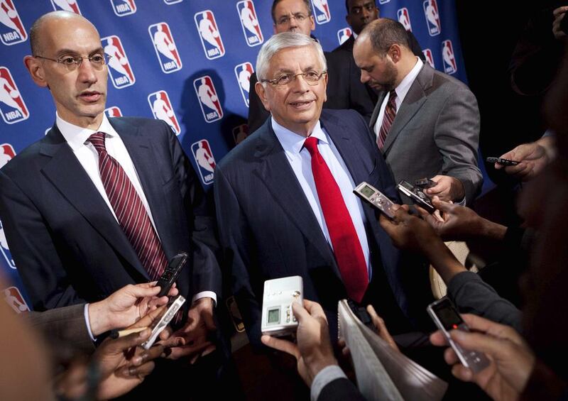 David Stern, centre, has retired and stepped down as his deputy Adam Silver takes over with the challenge to grow the sport. John Minchillo / AP Photo