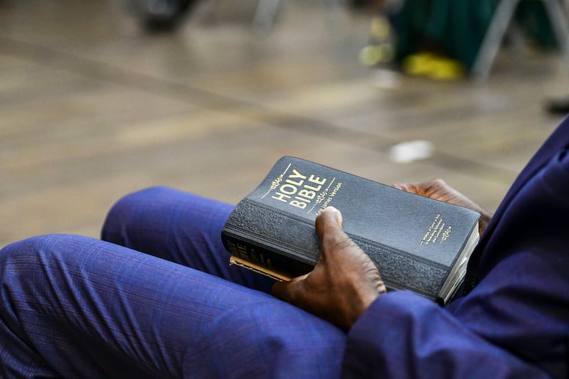 A devotee clutches a bible during mass.