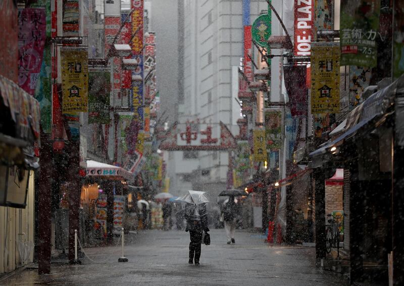 A man walks along a nearly empty street in a snow fall during the first weekend after Tokyo Governor Yuriko Koike urged Tokyo residents to stay indoors in a bid to keep coronavirus from spreading, at Ameyoko shopping and amusement district in Tokyo, Japan. Reuters