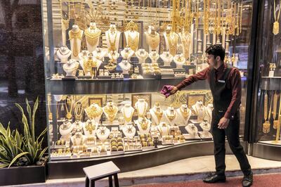 DUBAI, UNITED ARAB EMIRATES.  02 JULY 2018. The Gold Souk in Deira is due for an upgrade by the Munisipality. A man cleans a shop front window displaying gold jewellery. (Photo: Antonie Robertson/The National) Journalist: Anam Rizvi. Section: National.