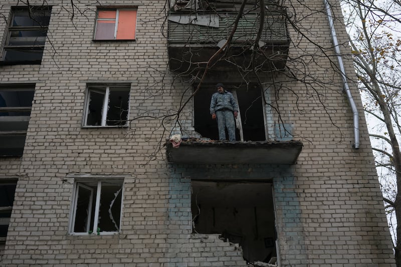 Oleksandr Antonenko, 53, stands on a balcony of his apartment damaged by a Russian rocket in Kherson, Ukraine. Reuters