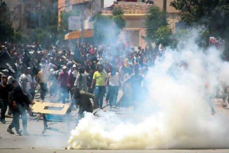 Ansar Al Shariah supporters clash with Tunisian police officers after Tunisia's Interior Ministry banned their annual conference in Kairouan, in Ettadhamen, near Tunis.