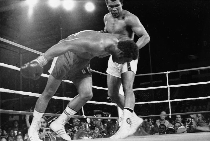 Challenger Muhammad Ali watches as defending world champion George Foreman goes down to the canvas in the eighth round of their WBA/WBC championship match in Kinshasa, Zaire, on October 30, 1974. Foreman is counted out by the referee and Ali regains the world heavyweight crown by KO in the bout dubbed 'Rumble in the Jungle.' (AP Photo)