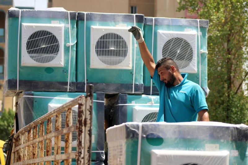 A delivery man unloads air condition units at a store in the Karada district of Baghdad in 2021, after temperatures exceeded 50°C. AFP