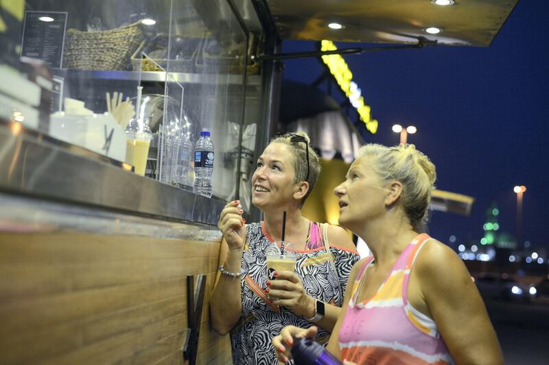 Abu Dhabi, United Arab Emirates - Left, Peggy Kandemir, 40 and Susan Sell, 42 from Germany  usually visit the food trucks after their daily jogging on May 23, 2018. (Khushnum Bhandari/ The National)