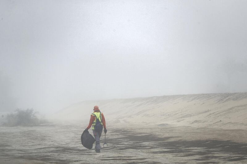 Dubai, United Arab Emirates - Reporter: N/A. News. A gentleman collects rubbish on the side of the road in the fog. Thursday, April 8th, 2021. Dubai. Chris Whiteoak / The National