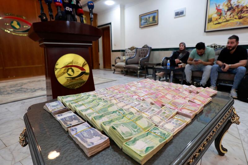 Iraqi banknotes are displayed during a press conference at the country's Integrity Commission in Baghdad on June 22. Many ordinary Iraqis despair of the country’s corruption problem and blame its political parties. AFP