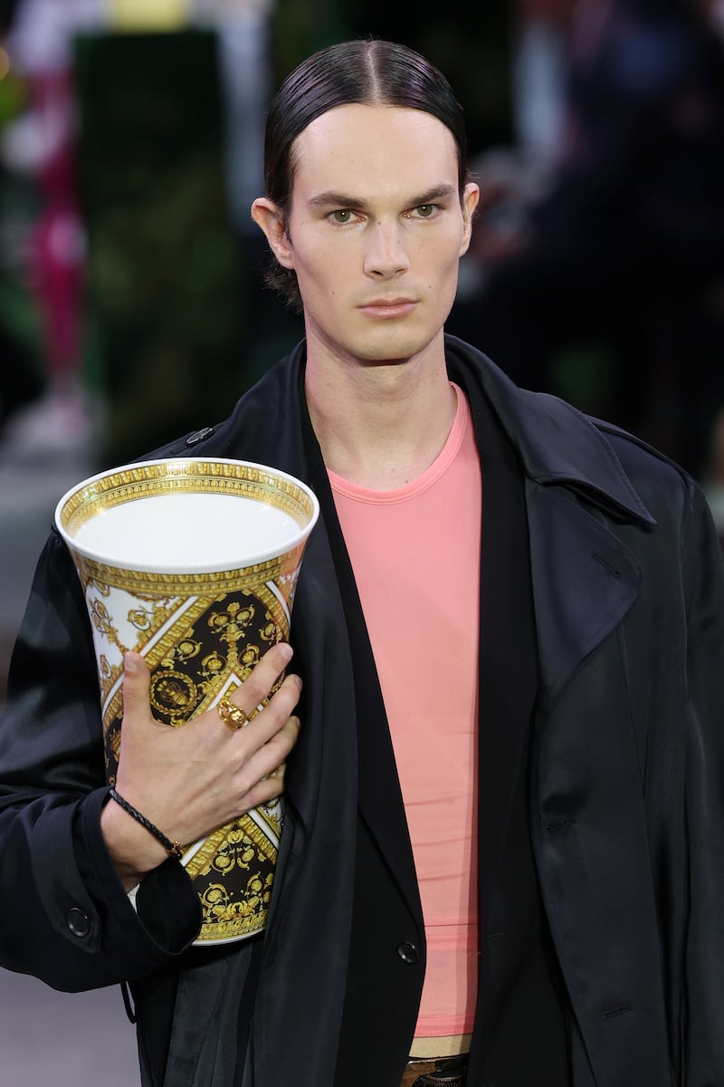 A model clutches a vase during the Versace spring/summer 2023 menswear show at Milan Fashion Week. Getty Images