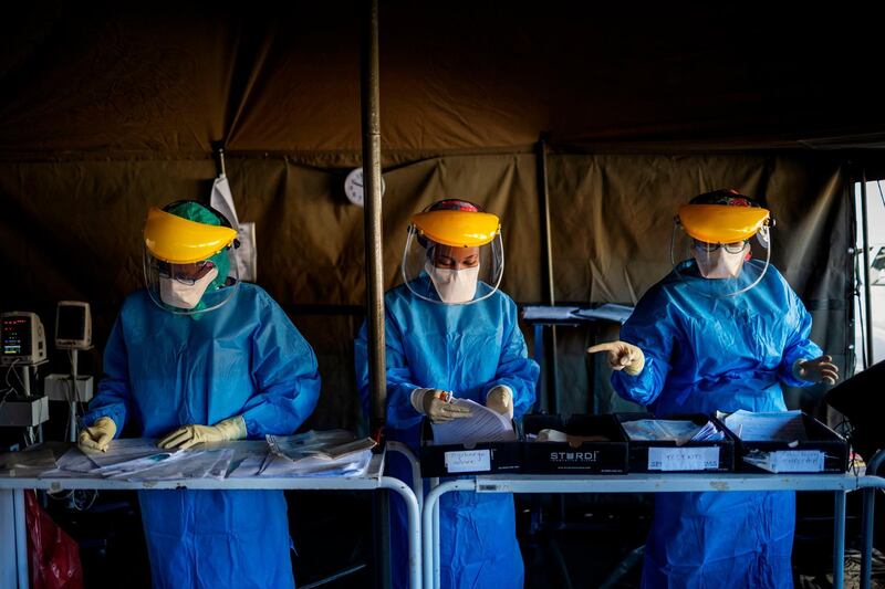 Health workers fill out documents before performing tests for COVID-19 coronavirus on other health workers at the screening and testing tents set up at the Charlotte Maxeke Hospital in Johannesburg.  AFP