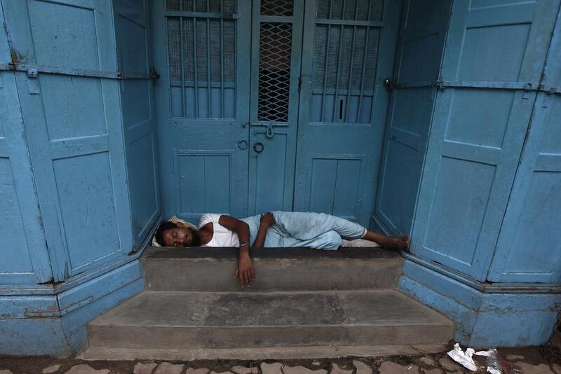 A man sleeps on the doorway of a closed shop at a market in Kolkata. Rupak De Chowdhuri / Reuters