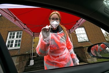 A Red Cross worker in protective clothes prepares to administer a Covid-19 rapid test. AP
