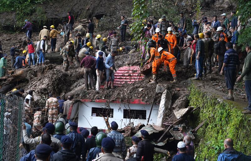 Rescuers remove debris as they search for people feared trapped after a landslide near Shimla, Himachal Pradesh. AP