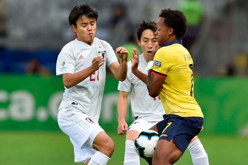 Japan's Takefusa Kubo, left, and Ecuador's Romario Ibarra vie for the ball. AFP