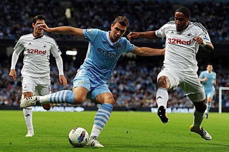 Edin Dzeko, centre, opened the scoring for Manchester City in their 4-0 win against Swansea City.